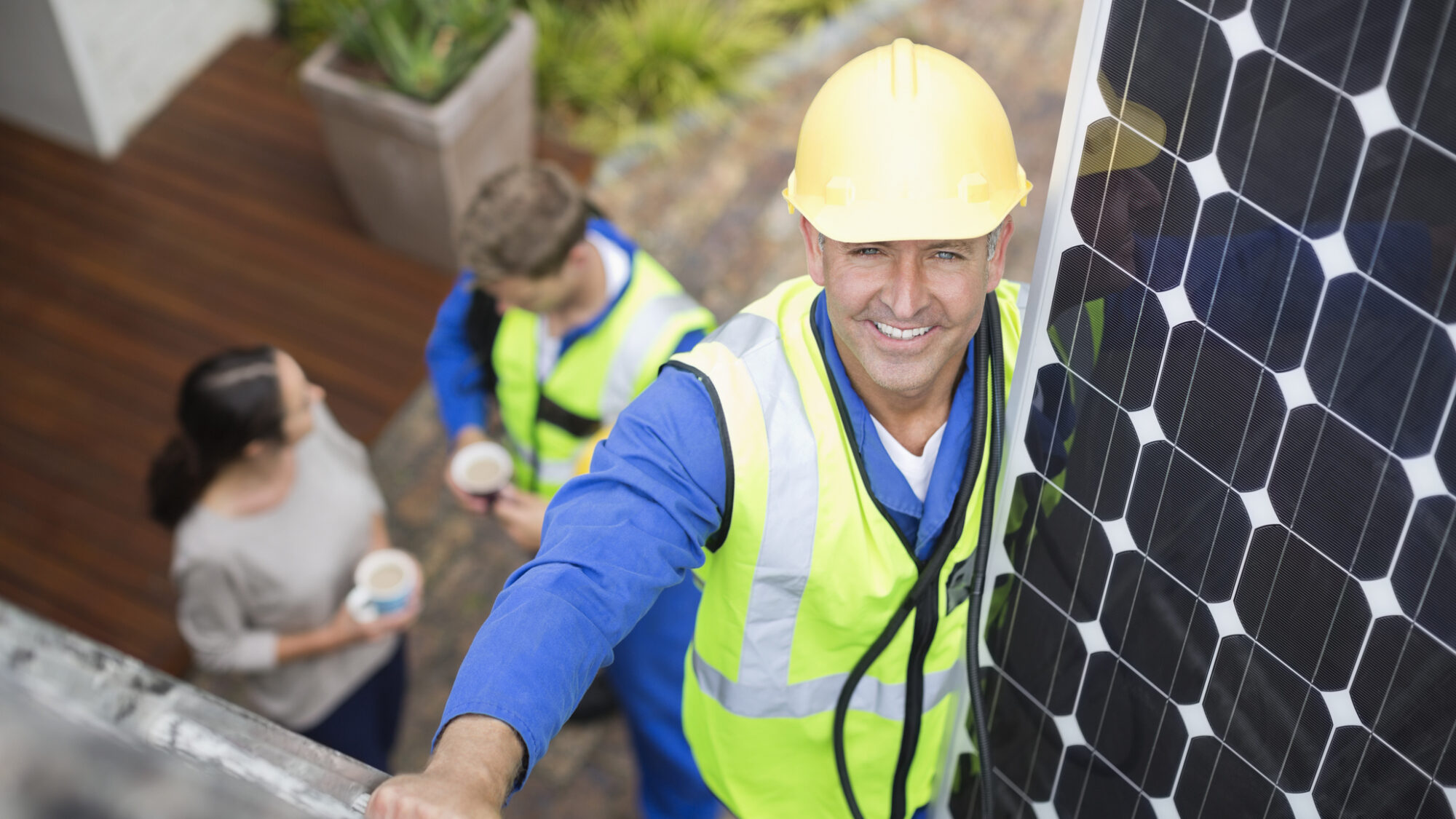 Worker installing solar panel on roof